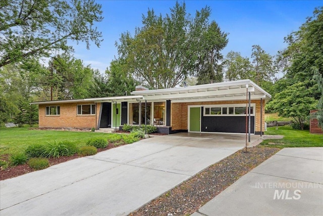 ranch-style home with driveway, a front lawn, and brick siding