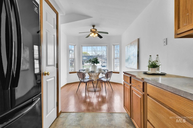 dining area with baseboards, light wood finished floors, and ceiling fan