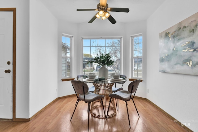 dining room with light wood-type flooring, baseboards, and a ceiling fan