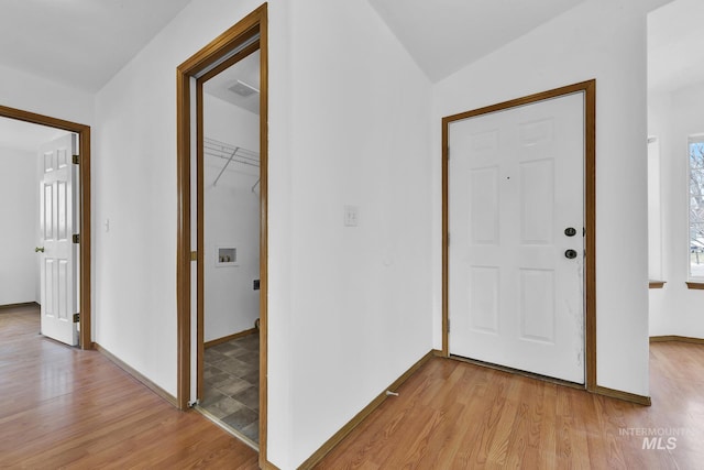 foyer entrance with baseboards, lofted ceiling, and light wood-style flooring