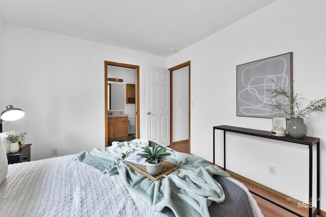 bedroom with wood finished floors and ensuite bathroom