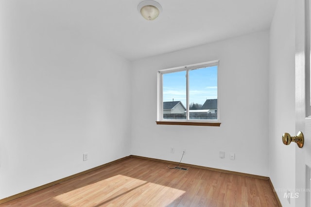 spare room with wood finished floors and baseboards