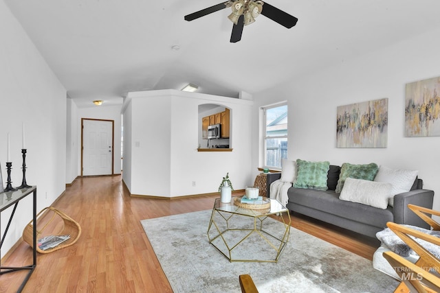 living area featuring vaulted ceiling, baseboards, a ceiling fan, and wood finished floors