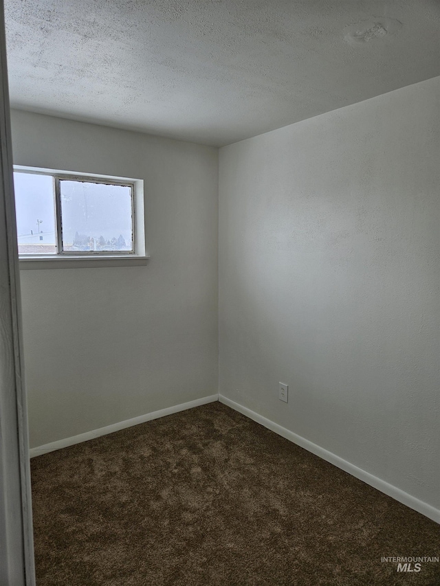 carpeted empty room featuring a textured ceiling