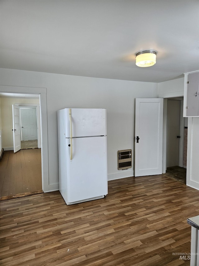 kitchen featuring white fridge, dark wood-type flooring, heating unit, and white cabinets