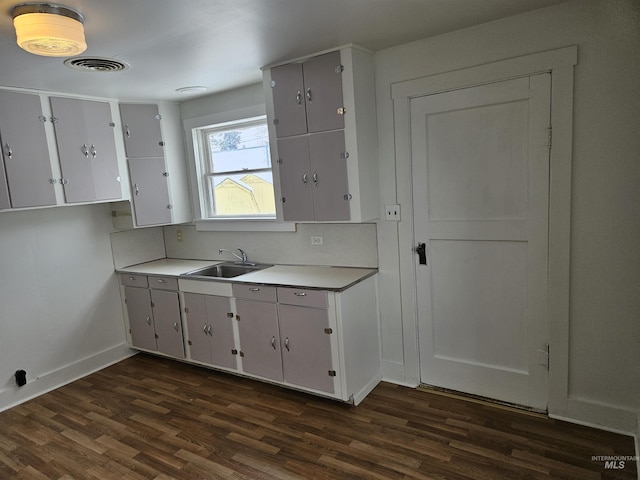 kitchen featuring white cabinetry, dark hardwood / wood-style floors, and sink