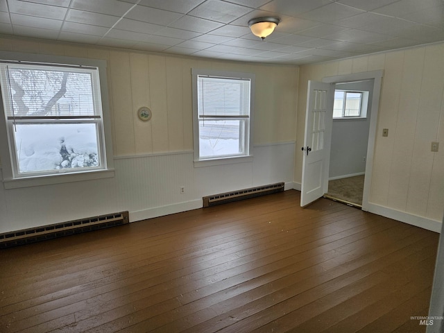 empty room featuring a baseboard radiator and dark wood-type flooring