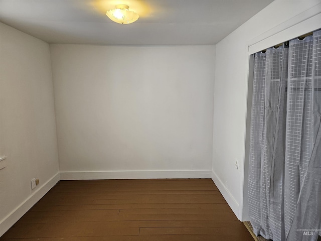 spare room with dark wood-type flooring