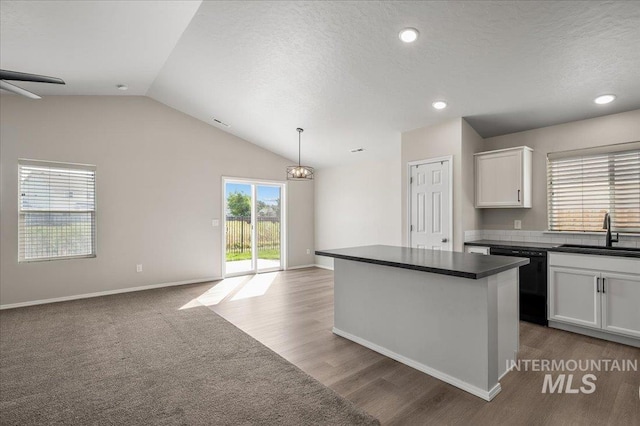 11177 Champlain Pl Unit 9, Caldwell, ID 83605 - kitchen featuring dishwasher, dark countertops, open floor plan, white cabinetry, and vaulted ceiling