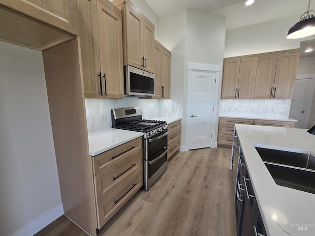 563 Full Moon Way, Twin Falls, ID 83301 - kitchen featuring stainless steel appliances, light wood finished floors, tasteful backsplash, recessed lighting, and hanging light fixtures