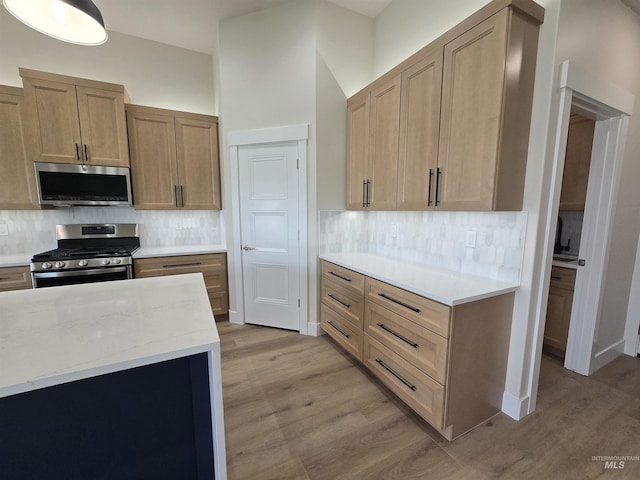 563 Full Moon Way, Twin Falls, ID 83301 - kitchen featuring stainless steel appliances, light wood-style flooring, backsplash, and light stone counters