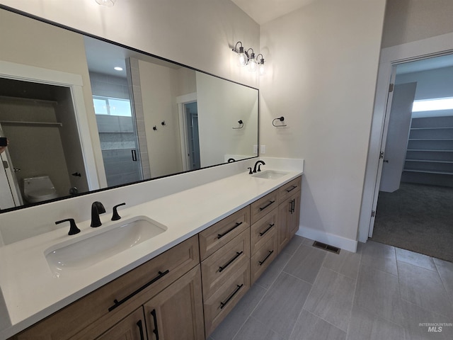 563 Full Moon Way, Twin Falls, ID 83301 - full bath featuring double vanity, a stall shower, a walk in closet, and tile patterned floors