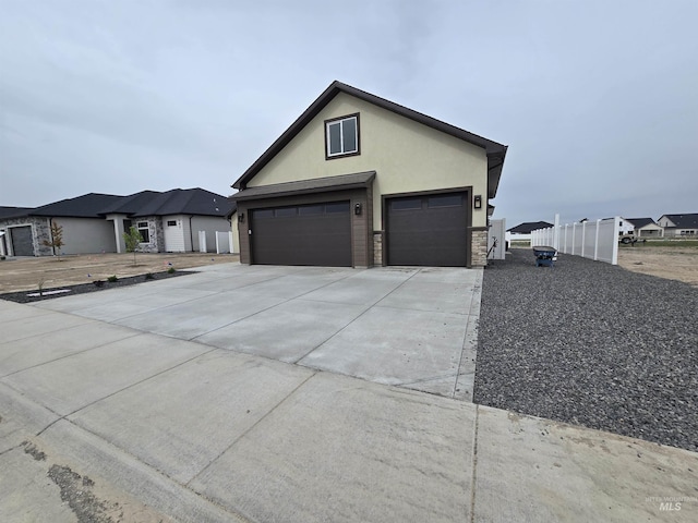 563 Full Moon Way, Twin Falls, ID 83301 - traditional-style home featuring a garage, stucco siding, driveway, and stone siding