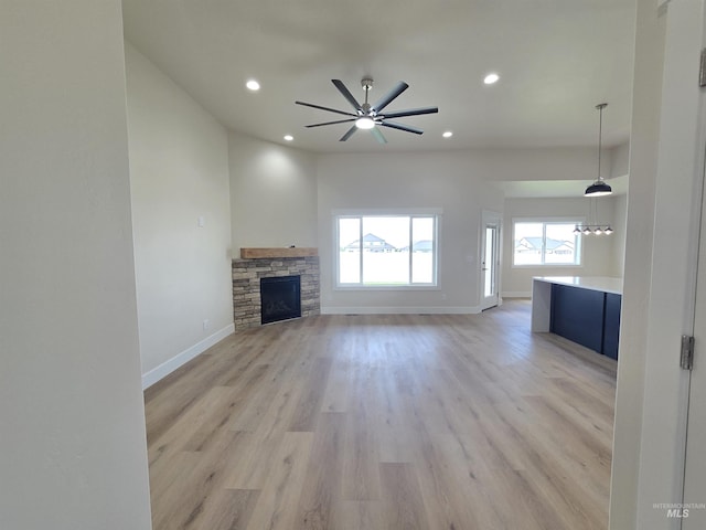 563 Full Moon Way, Twin Falls, ID 83301 - unfurnished living room with recessed lighting, light wood-style floors, ceiling fan, and a stone fireplace