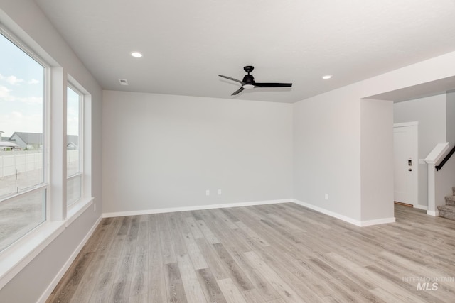 empty room with ceiling fan and light hardwood / wood-style floors