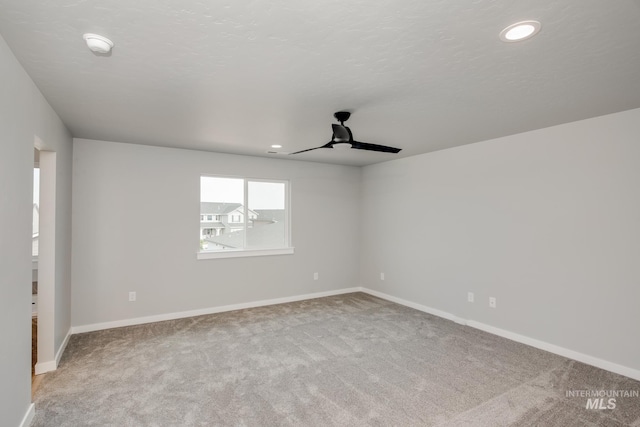 spare room featuring light colored carpet and ceiling fan