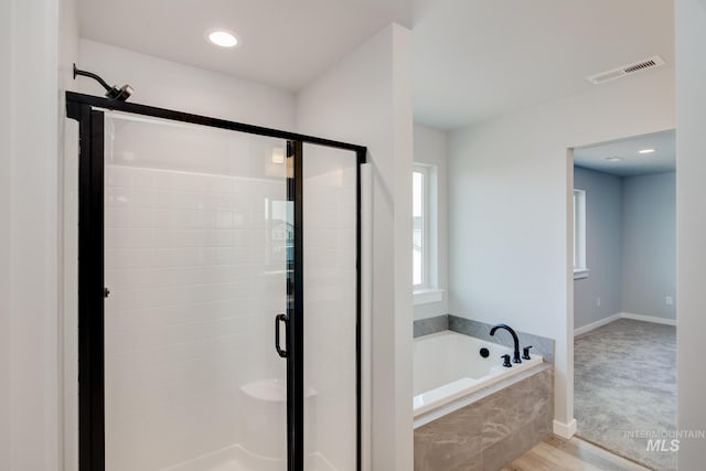 bathroom featuring shower with separate bathtub