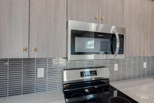 kitchen featuring appliances with stainless steel finishes, light stone counters, and light brown cabinetry