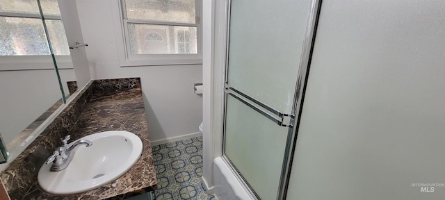 full bathroom with toilet, vanity, and combined bath / shower with glass door