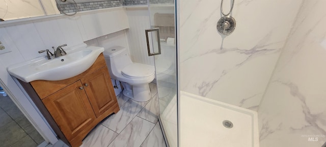 bathroom with walk in shower, vanity, tile walls, and toilet