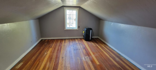 additional living space featuring lofted ceiling and dark hardwood / wood-style flooring