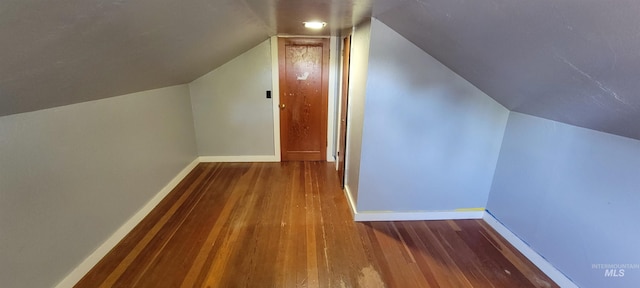 additional living space featuring vaulted ceiling and hardwood / wood-style flooring