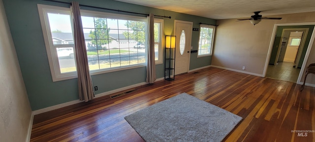 interior space with a textured ceiling, ceiling fan, and dark hardwood / wood-style flooring