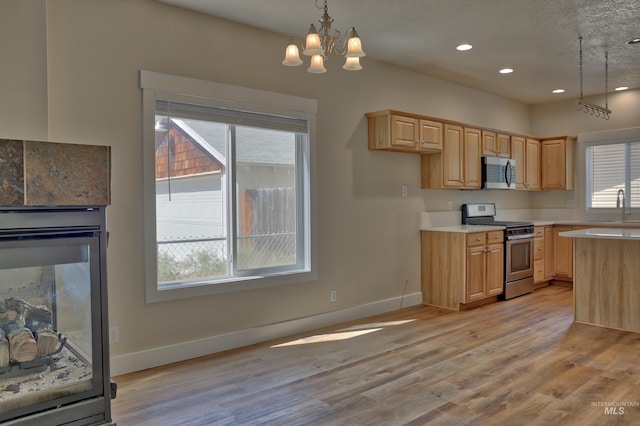 1421 S Denver Ave, Boise, ID 83706 - kitchen featuring appliances with stainless steel finishes, light countertops, a sink, light brown cabinetry, and a chandelier