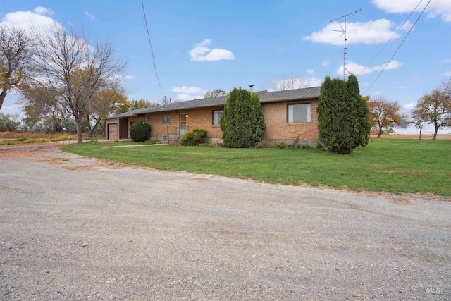 425 W 700 N, Paul, ID 83347 - view of side of home with brick siding, a garage, a yard, and dirt driveway
