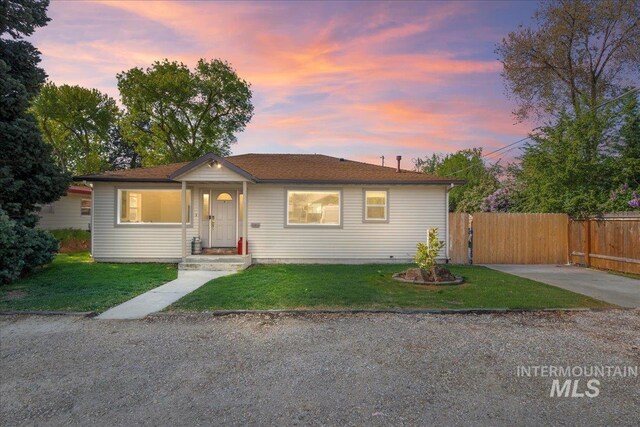 view of front facade featuring a yard and fence