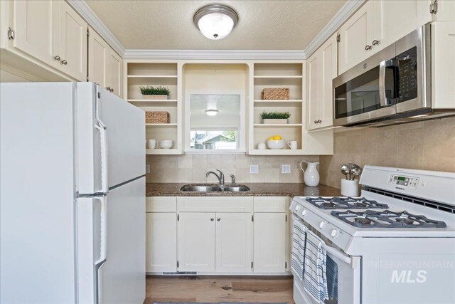 kitchen featuring white cabinets, open shelves, a sink, white appliances, and decorative backsplash