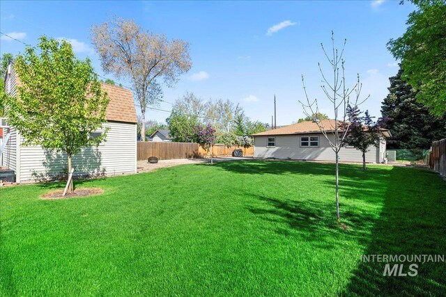 view of yard with an outdoor structure and a fenced backyard