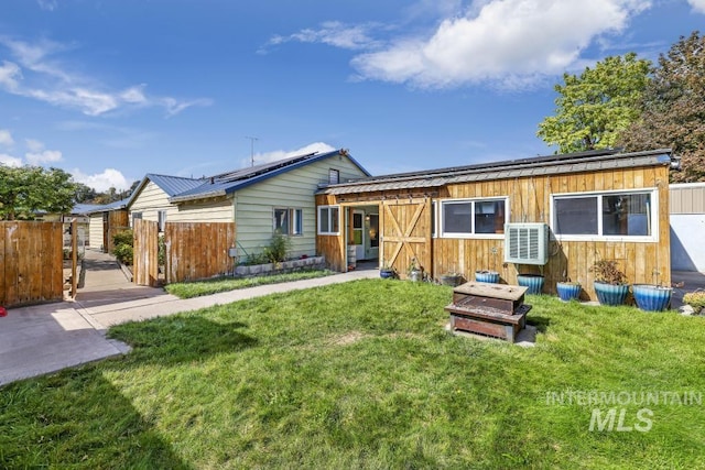 view of front facade with metal roof, a front yard, ac unit, fence, and roof mounted solar panels