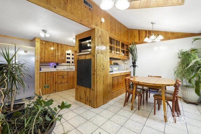 kitchen with brown cabinets, a notable chandelier, light countertops, stainless steel appliances, and visible vents
