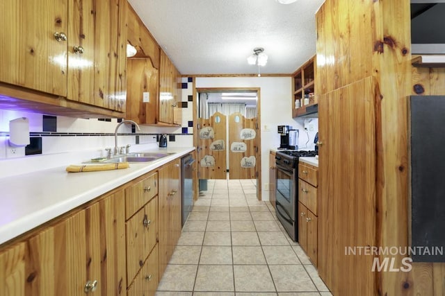 kitchen featuring a sink, dishwasher, light countertops, brown cabinetry, and black gas range