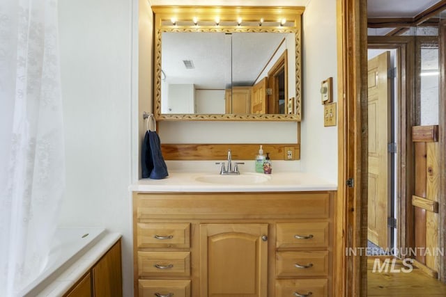bathroom featuring vanity, a bathtub, and visible vents