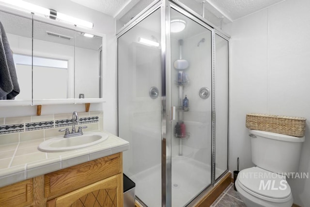 full bathroom featuring backsplash, visible vents, a shower stall, vanity, and toilet