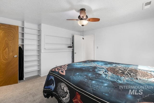 bedroom with ceiling fan, carpet, a textured ceiling, and visible vents