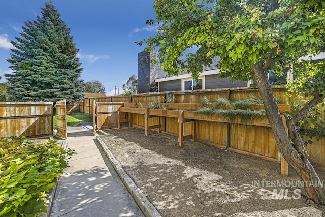 view of yard featuring a fenced backyard and a gate