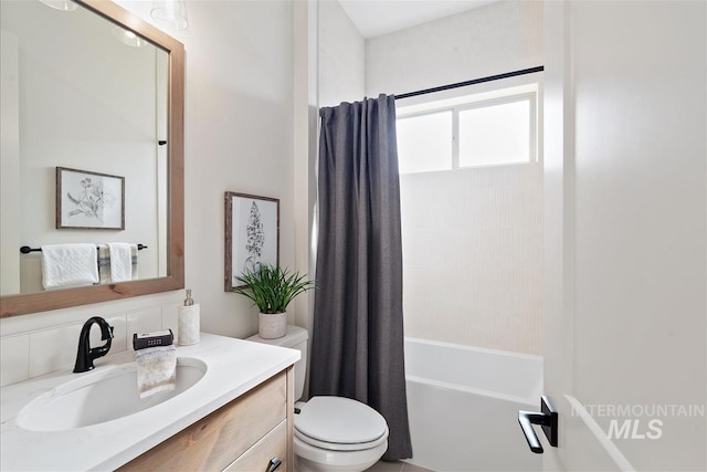 full bathroom featuring toilet, shower / bath combination with curtain, and vanity