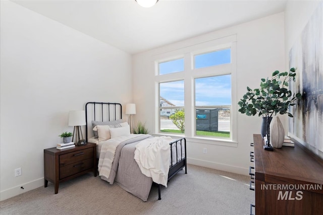 bedroom with baseboards and light colored carpet