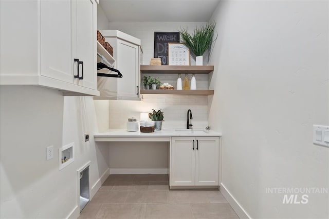 laundry room with light tile patterned flooring, hookup for a washing machine, hookup for an electric dryer, a sink, and cabinet space