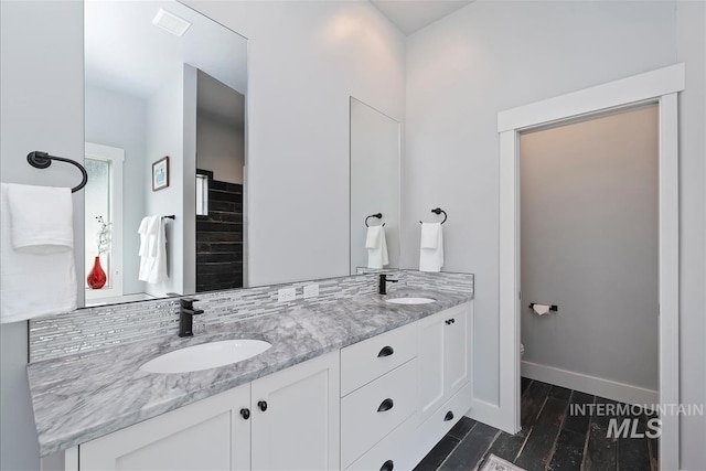 3090 NW 13th St, Meridian, ID 83646 - bathroom with a sink, baseboards, double vanity, and wood finished floors