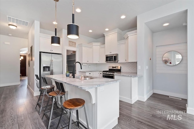 3090 NW 13th St, Meridian, ID 83646 - kitchen featuring visible vents, dark wood-style flooring, an island with sink, a sink, and stainless steel appliances