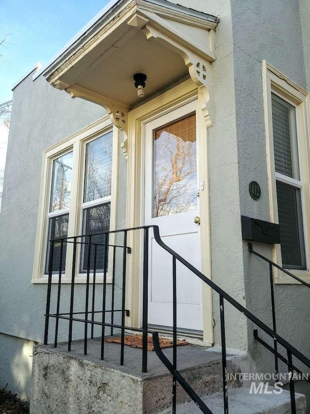 view of exterior entry featuring stucco siding