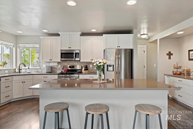 12131 W Precept Ln, Kuna, ID 83634 - kitchen with appliances with stainless steel finishes, a breakfast bar, dark wood-style floors, and recessed lighting