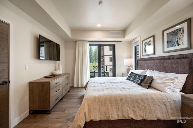 bedroom with dark hardwood / wood-style floors and access to exterior