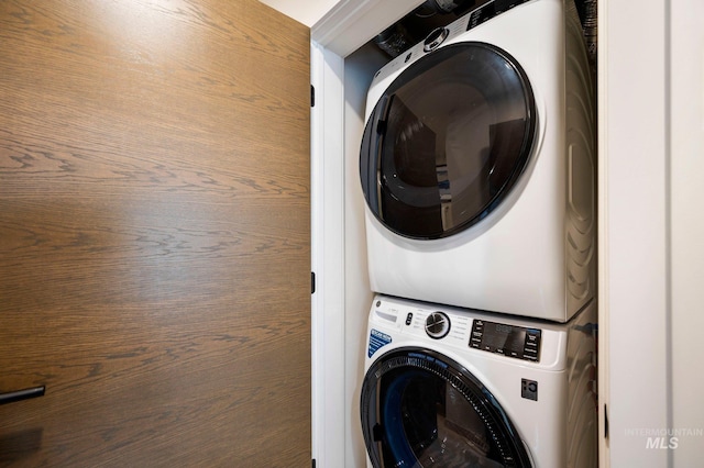 clothes washing area featuring stacked washer / drying machine