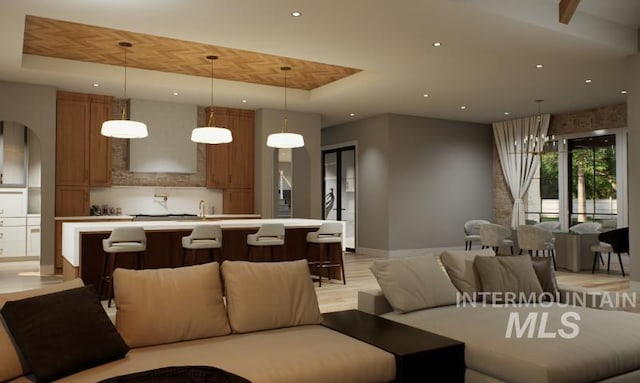 1054 N Delehaye Ave, Eagle, ID 83616 - living room with a tray ceiling, arched walkways, recessed lighting, and baseboards