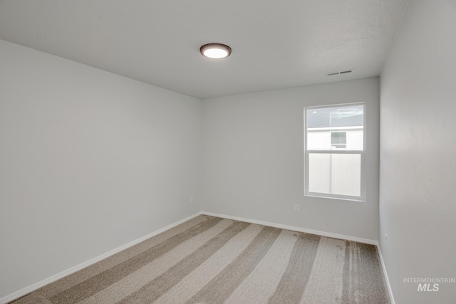 carpeted empty room with visible vents and baseboards